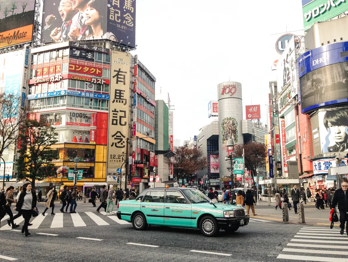 Photo of a taxi in a busy intersection in Tokyo.
