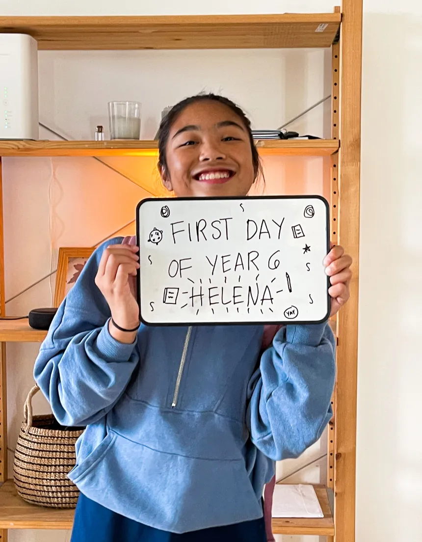 A child holding a sign that says “First day of Grade 6 - Helena”